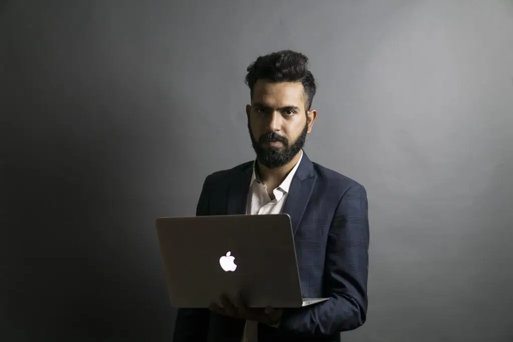 mies kannettavan tietokoneen kanssa