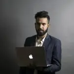 mies kannettavan tietokoneen kanssa